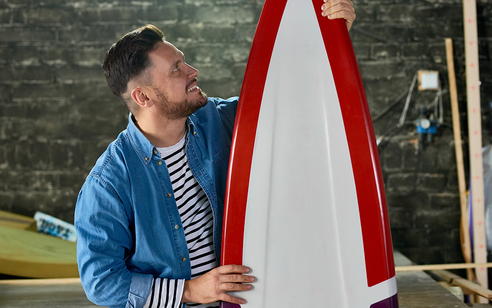 Homem apreciando o design em resina para pranchas de surf