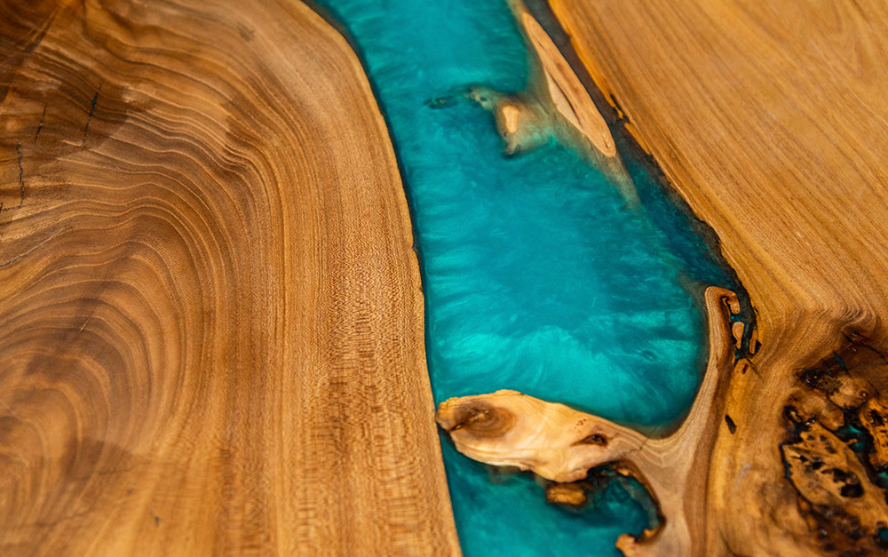 Móveis de madeira com resina representado por uma mesa com técnica River Table